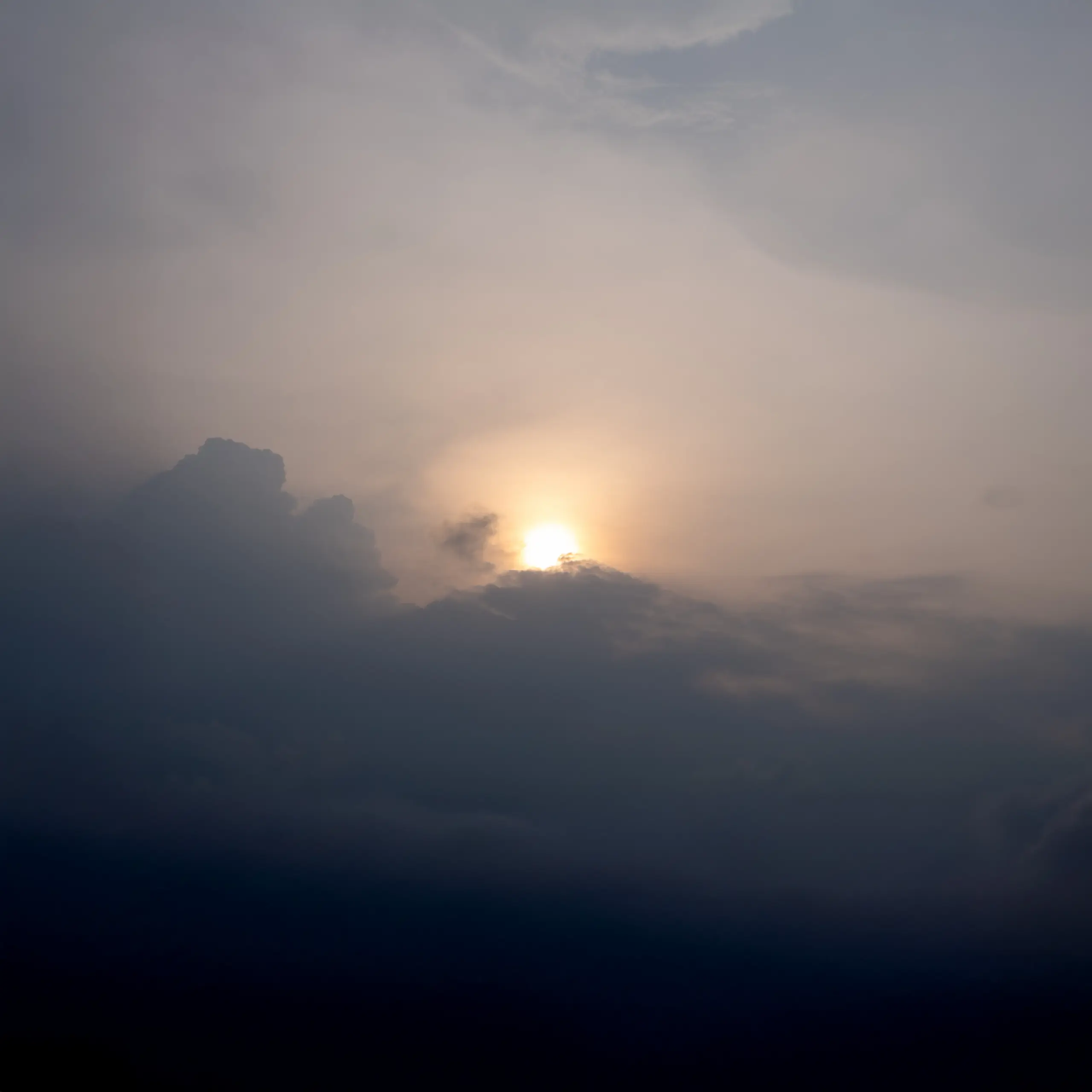 A dramatic sunset under textured, cloudy skies.